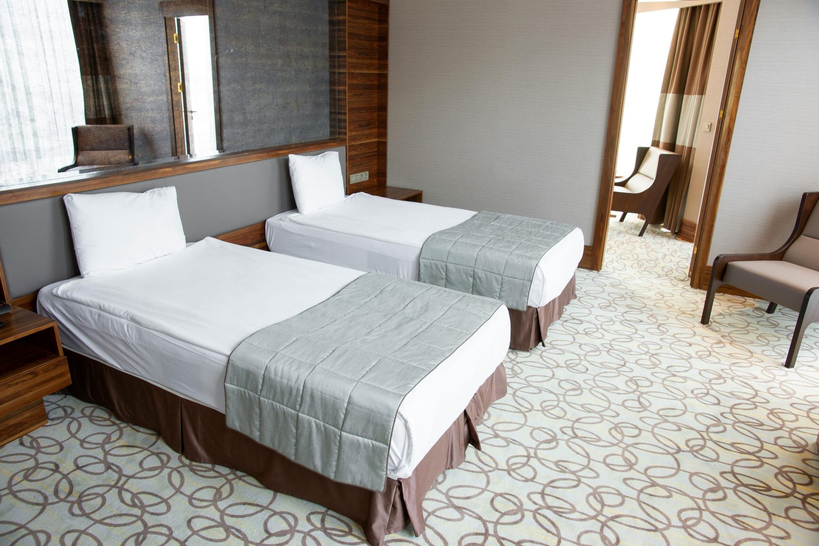 Spacious and luxurious hotel room featuring two comfortable twin beds with stylish design.